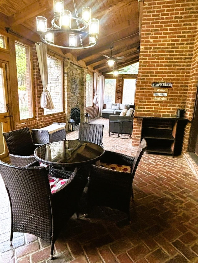 dining room with a fireplace, lofted ceiling with beams, brick wall, wooden ceiling, and a chandelier