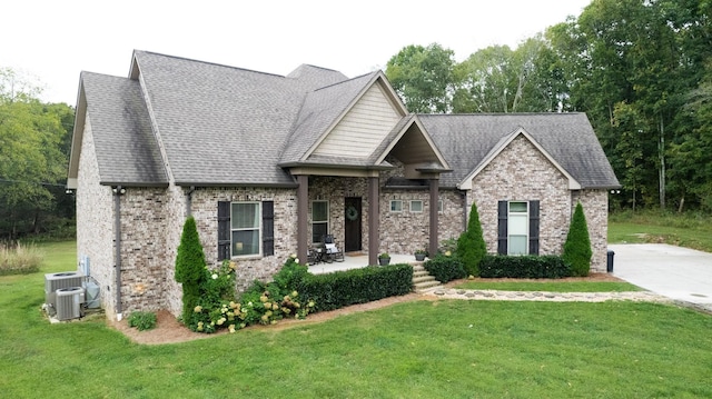 view of front of property featuring a front lawn, central AC unit, and a patio