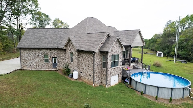 back of house featuring a yard and a shed