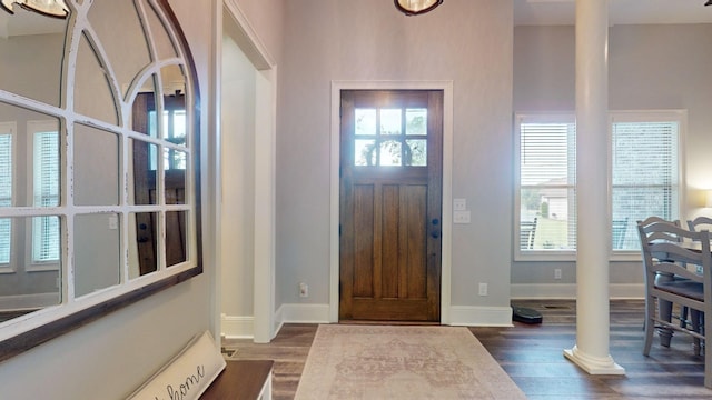 entryway with a healthy amount of sunlight, dark hardwood / wood-style floors, and decorative columns