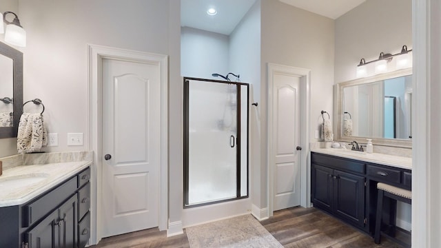 bathroom with hardwood / wood-style flooring, an enclosed shower, and vanity