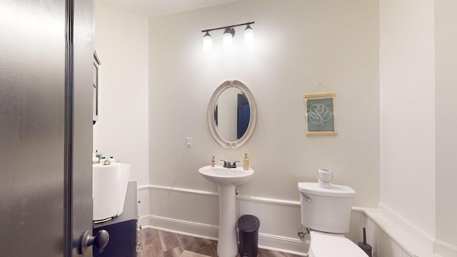 bathroom with toilet, wood-type flooring, and sink