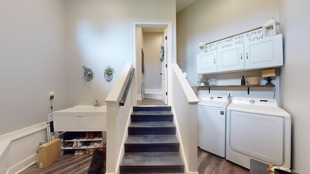 staircase with washing machine and dryer and hardwood / wood-style floors