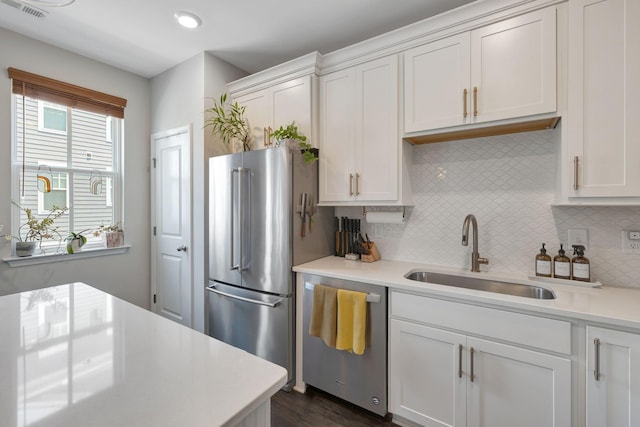 kitchen with white cabinets, backsplash, sink, and stainless steel appliances