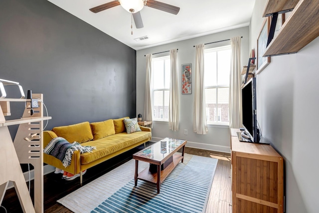 living room featuring ceiling fan, a healthy amount of sunlight, and dark hardwood / wood-style flooring