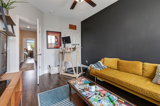 living room featuring ceiling fan and dark hardwood / wood-style flooring