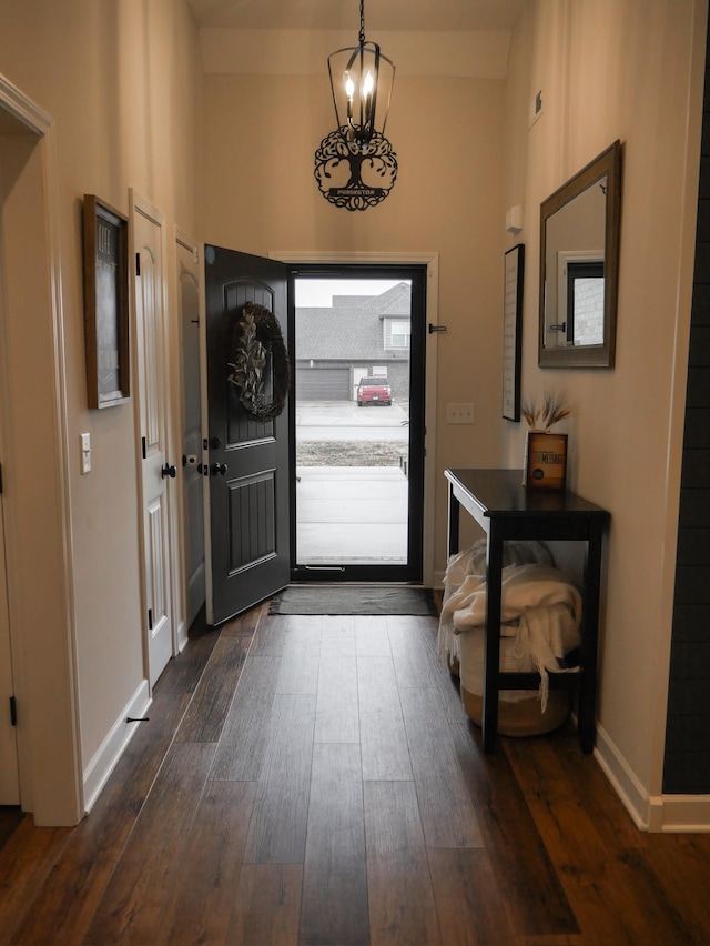 entrance foyer featuring dark wood-type flooring and a notable chandelier