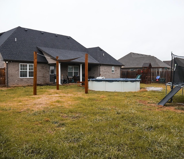 view of yard with a playground, a trampoline, and a covered pool