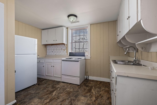 kitchen with white appliances, white cabinetry, sink, backsplash, and wood walls