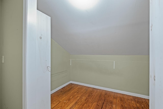 additional living space with vaulted ceiling and hardwood / wood-style flooring