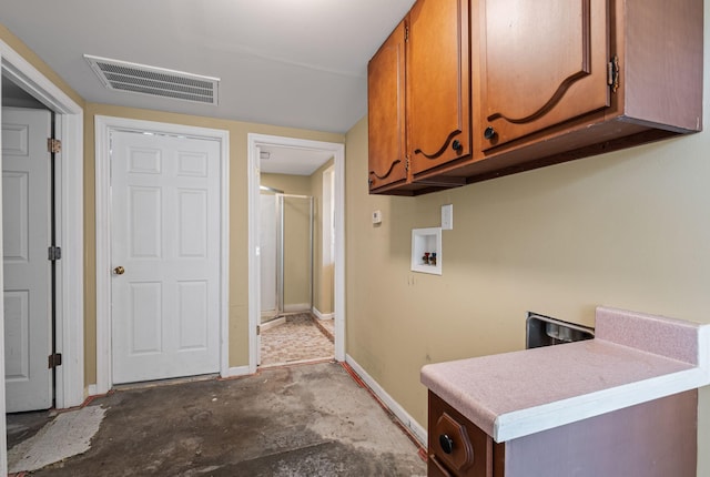 washroom with washer hookup and cabinets