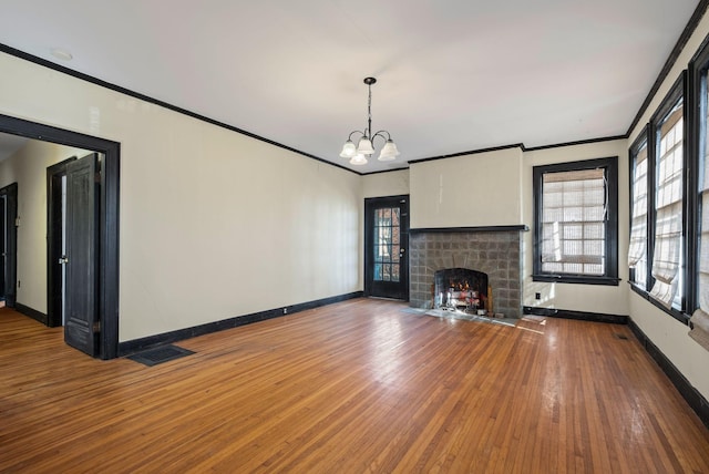 unfurnished living room featuring crown molding, a fireplace, an inviting chandelier, and hardwood / wood-style flooring