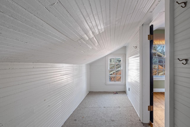 bonus room featuring light colored carpet, vaulted ceiling, wood walls, and wooden ceiling