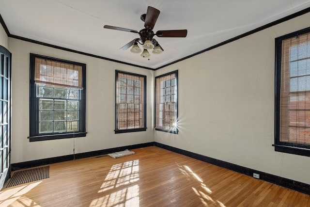 empty room with ceiling fan, ornamental molding, and light hardwood / wood-style flooring