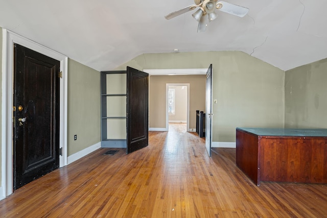 interior space with vaulted ceiling, ceiling fan, and hardwood / wood-style flooring