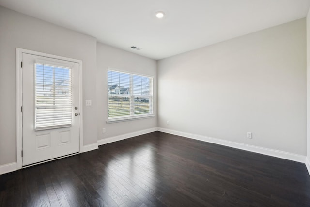 unfurnished room featuring dark hardwood / wood-style flooring and plenty of natural light