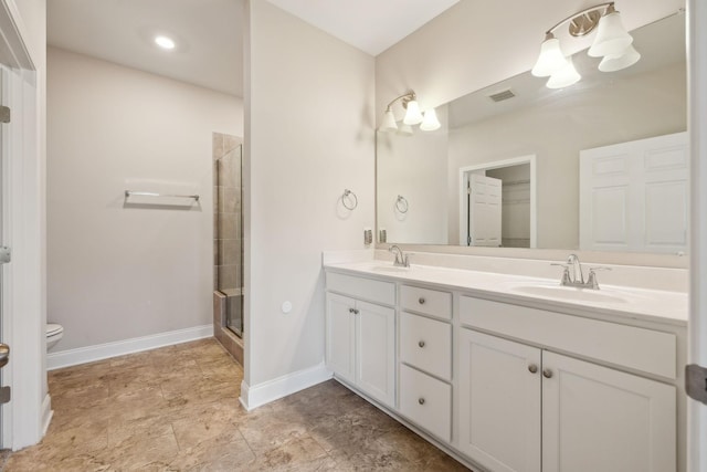 bathroom with a shower with shower door, vanity, and toilet