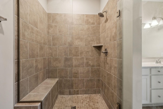 bathroom with vanity and tiled shower