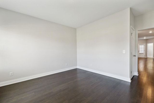 empty room with dark hardwood / wood-style flooring