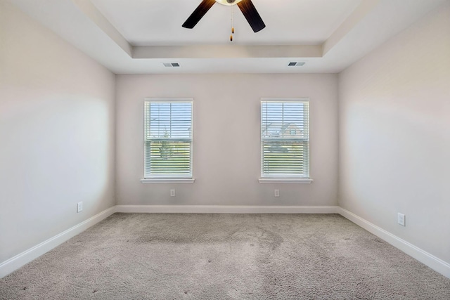 unfurnished room with carpet floors, a raised ceiling, and ceiling fan