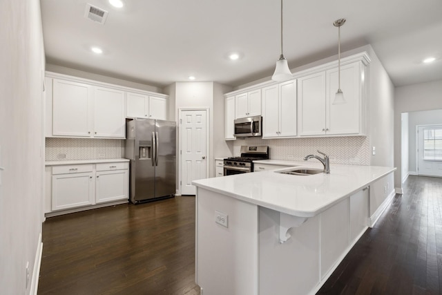 kitchen with sink, pendant lighting, white cabinets, and stainless steel appliances