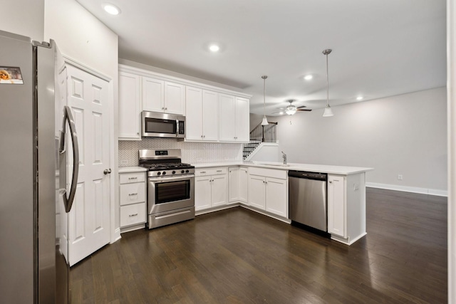 kitchen featuring white cabinetry, stainless steel appliances, pendant lighting, and kitchen peninsula