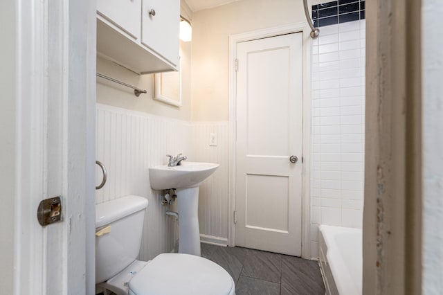 bathroom with toilet and a tub to relax in