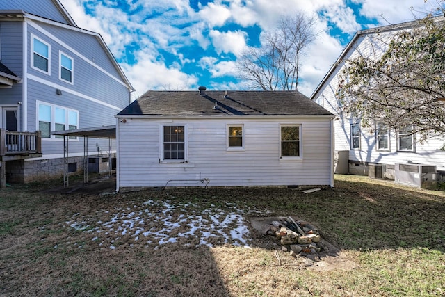 rear view of property with cooling unit and a lawn