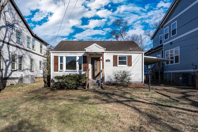 view of front of property with a front yard, cooling unit, and a carport