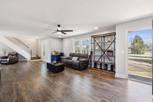 living room featuring ceiling fan and dark hardwood / wood-style flooring