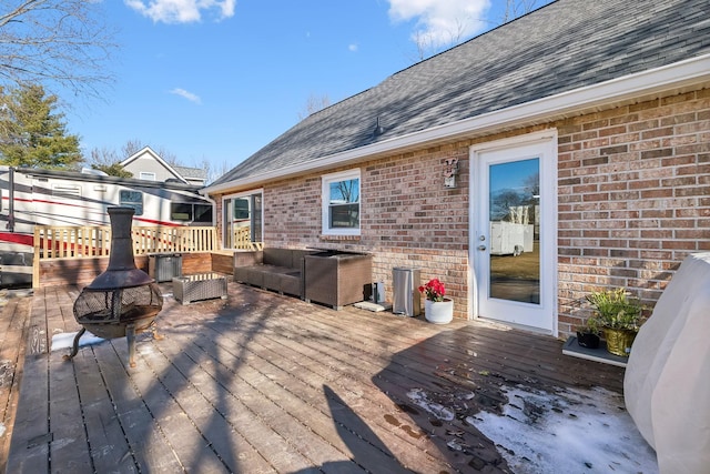 deck featuring an outdoor living space with a fire pit