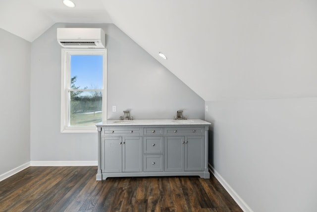 interior space featuring vaulted ceiling, dark hardwood / wood-style floors, sink, and a wall unit AC