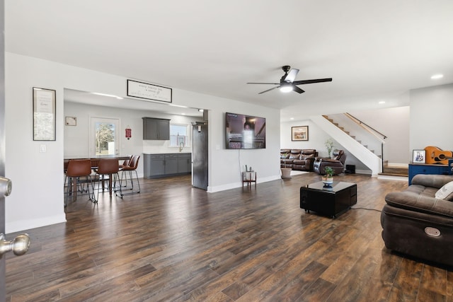 living room with dark wood-type flooring, ceiling fan, and sink