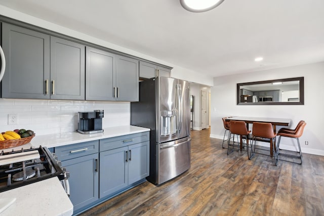 kitchen with stainless steel appliances, dark hardwood / wood-style flooring, and backsplash