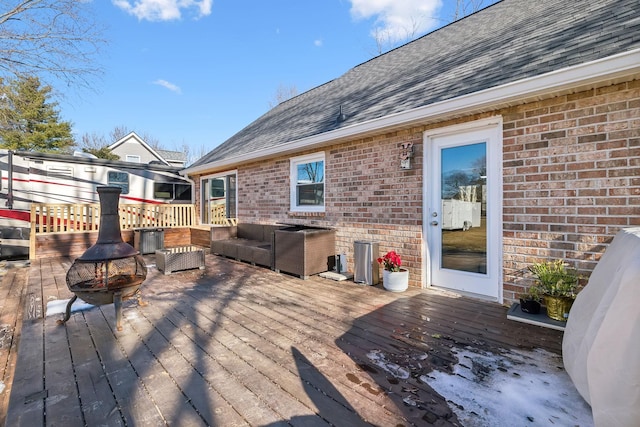 wooden deck featuring an outdoor living space with a fire pit