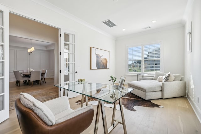 interior space with crown molding, a notable chandelier, light hardwood / wood-style flooring, and french doors