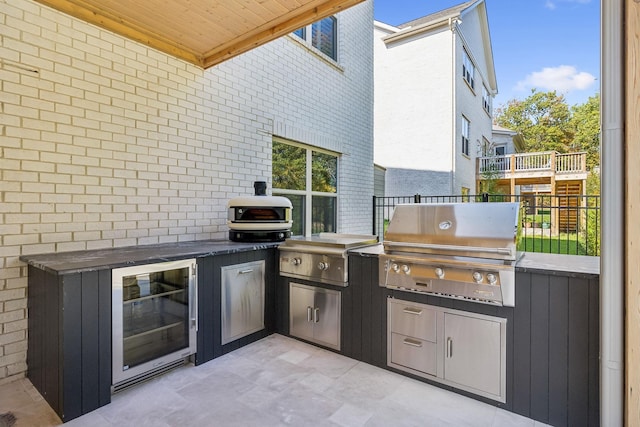 view of patio / terrace featuring an outdoor kitchen, a grill, and beverage cooler