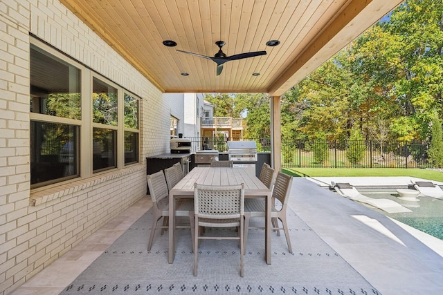 view of patio / terrace with exterior kitchen, ceiling fan, a pool, and grilling area