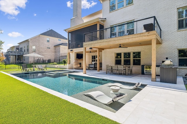 view of swimming pool featuring an outdoor bar, ceiling fan, a fireplace, a patio area, and an in ground hot tub