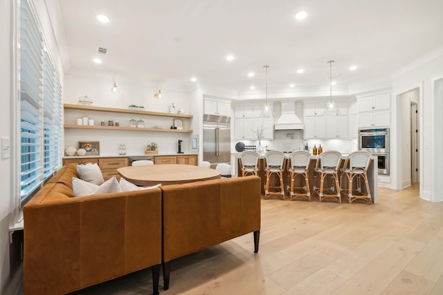 living room with crown molding and light hardwood / wood-style flooring