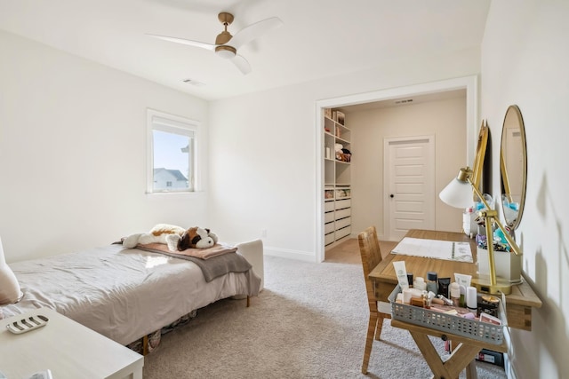 bedroom featuring light carpet, a spacious closet, a closet, and ceiling fan