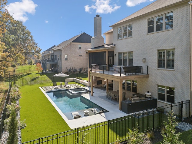 back of house featuring a yard, a patio area, a sunroom, a pool with hot tub, and area for grilling