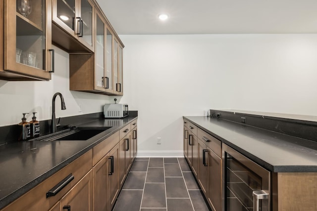 kitchen with sink, beverage cooler, and dark tile patterned floors