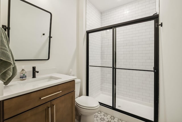 bathroom with a shower with door, vanity, and toilet