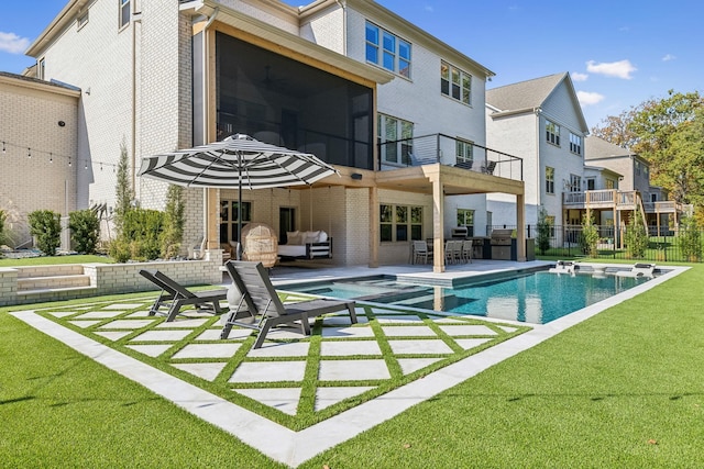 rear view of property featuring a balcony, a yard, a patio, a fenced in pool, and a sunroom