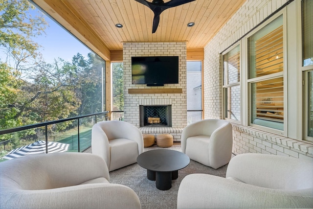 balcony featuring an outdoor brick fireplace and ceiling fan