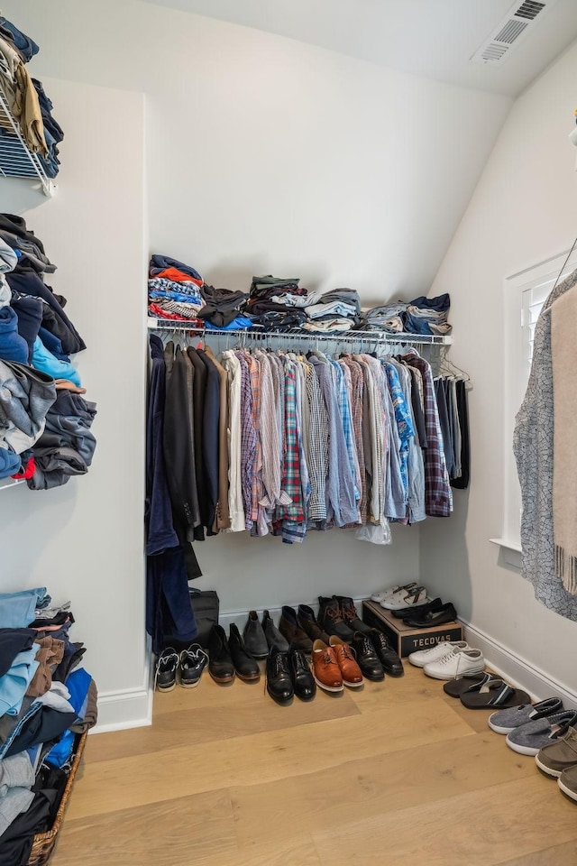 walk in closet featuring lofted ceiling and wood-type flooring