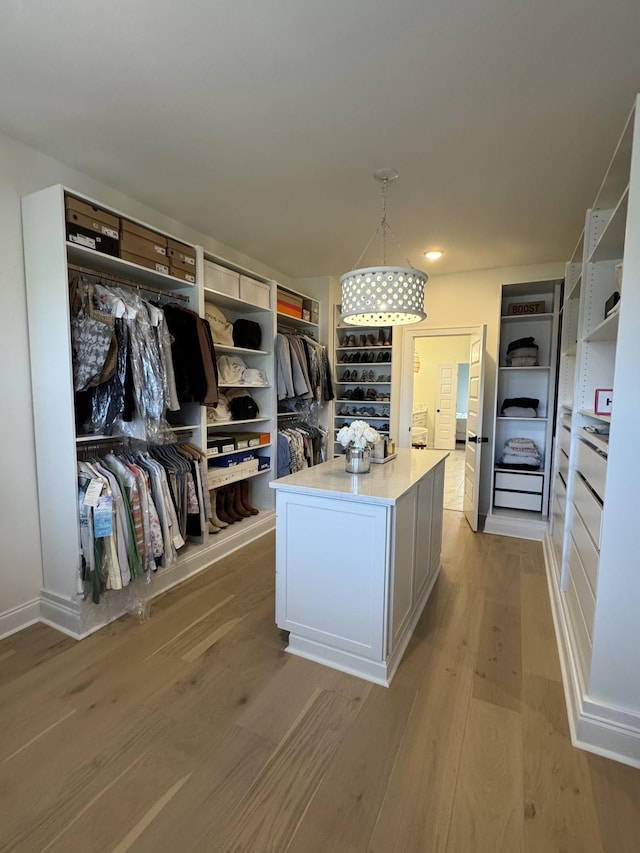 kitchen featuring white cabinetry, pendant lighting, light hardwood / wood-style flooring, and a center island