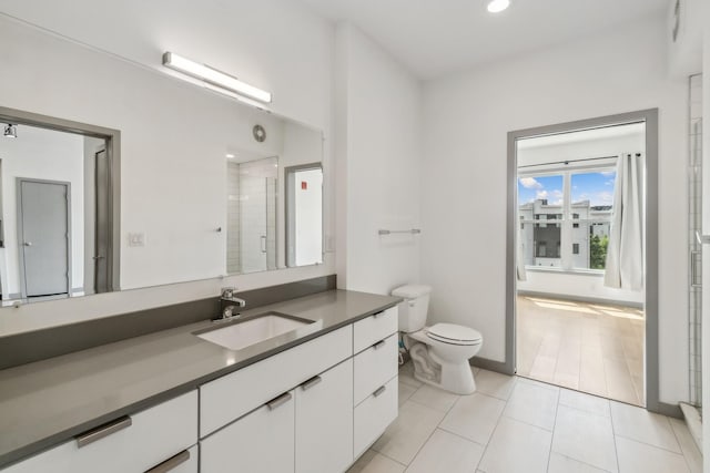 bathroom featuring toilet, walk in shower, tile patterned floors, and vanity