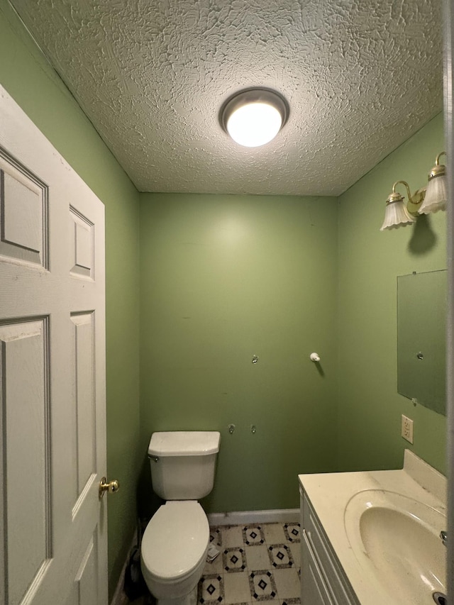 bathroom with toilet, a textured ceiling, and vanity